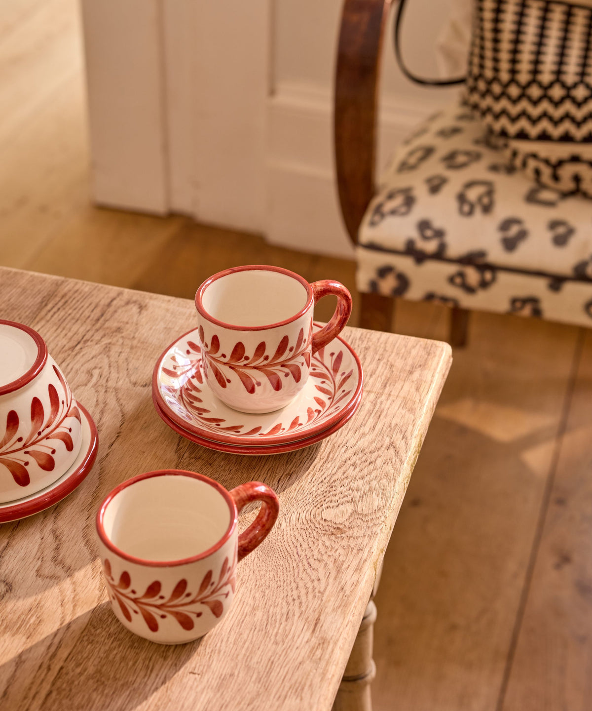 Hand-painted Helecho coffee cup in Rust Red on the table, Carmen del Viboral