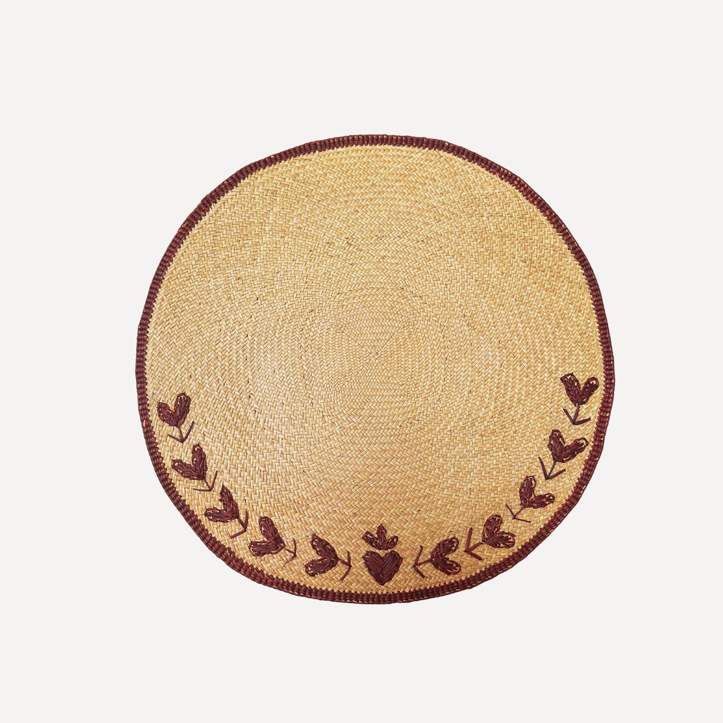 Round woven placemat with nordic heart design embroidered decorative border on a white background
