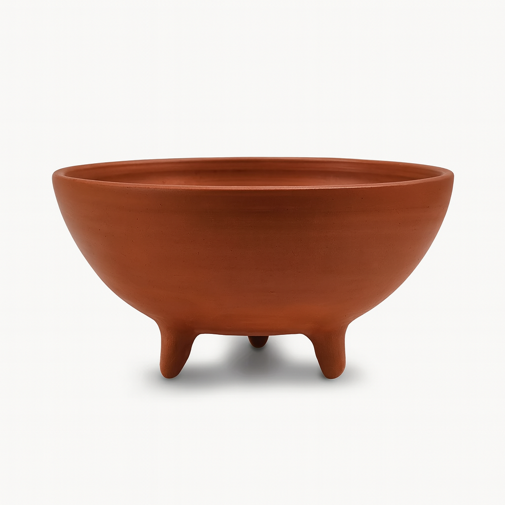 Terracotta-colored bowl with three legs on a white background