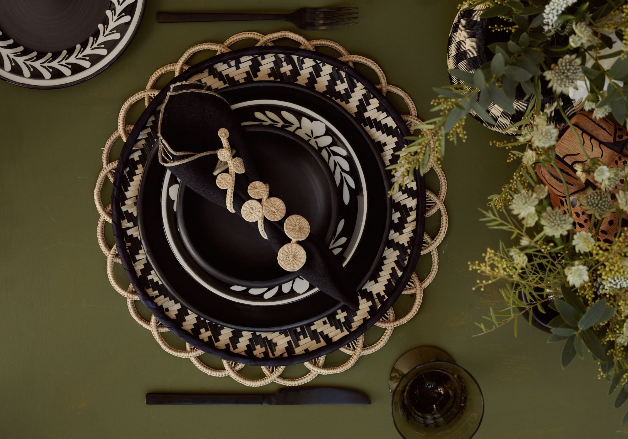 Table setting with layered hanwoven placemats and napkin rings