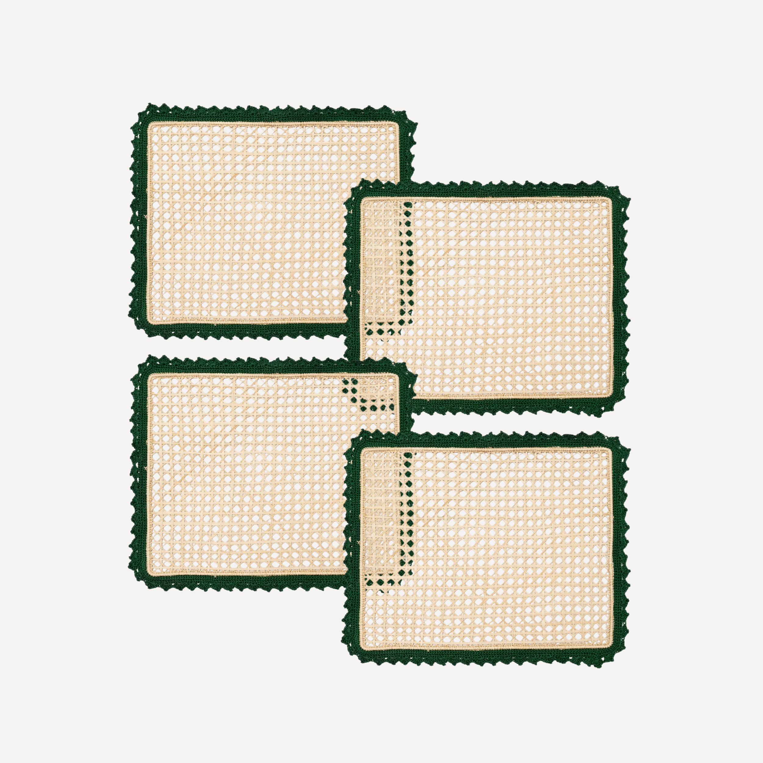 Four rectangular handmade placemats with green crochet boarder and rattan woven center on a white background