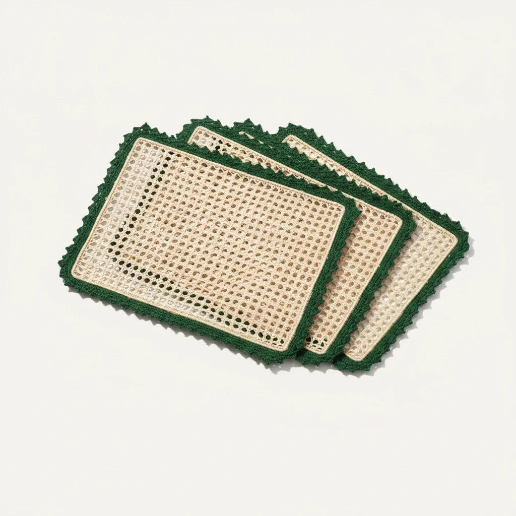 Set of four woven placemats with green crochet borders on a light background